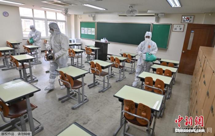 资料图:当地时间5月11日,韩国,首尔一所高中的教室里,卫生官员穿着防护服喷洒消毒剂。 资料图:当地时间5月11日,韩国,首尔一所高中的教室里,卫生官员穿着防护服喷洒消毒剂。