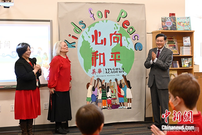 图为英华学院校长包善容（中）向秦刚（右）赠送学生制作的“心向和平”（Kids for Peace）海报。 中新社记者 陈孟统 摄