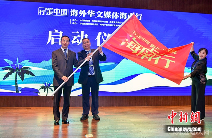 图为海南省委常委、宣传部部长、省政府副省长王斌（左）向罗马尼亚《欧洲侨报》社长高进（中），加拿大共生国际传媒社长胡宪授旗。 中新社记者 骆云飞 摄