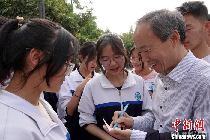 论坛闭幕后，王心源研究员应邀参访腾冲第一中学与学生代表座谈交流，为学生签名寄语。　中新社记者 孙自法 摄