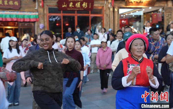 图为“Z世代”海内外青年在独克宗古城与当地居民及游客跳舞。 何显津 摄 图为“Z世代”海内外青年在独克宗古城与当地居民及游客跳舞。 何显津 摄